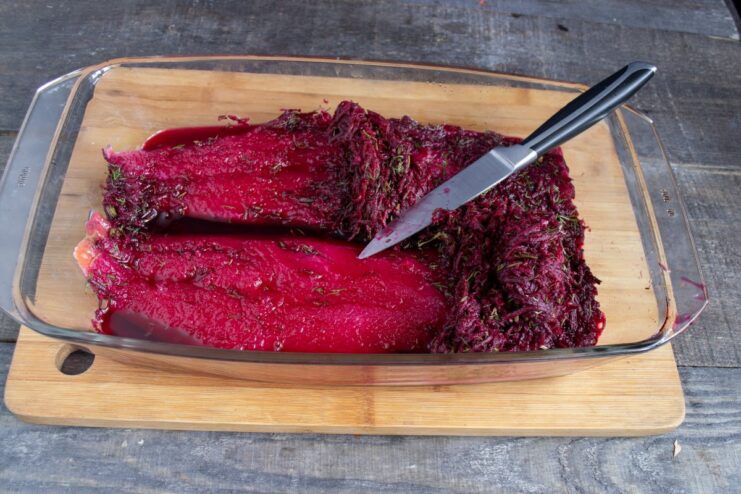 Unveiling the Cured Beetroot Gravlax Scraping the beetroot cure off the salmon fillet to reveal the beautifully stained, cured fish.