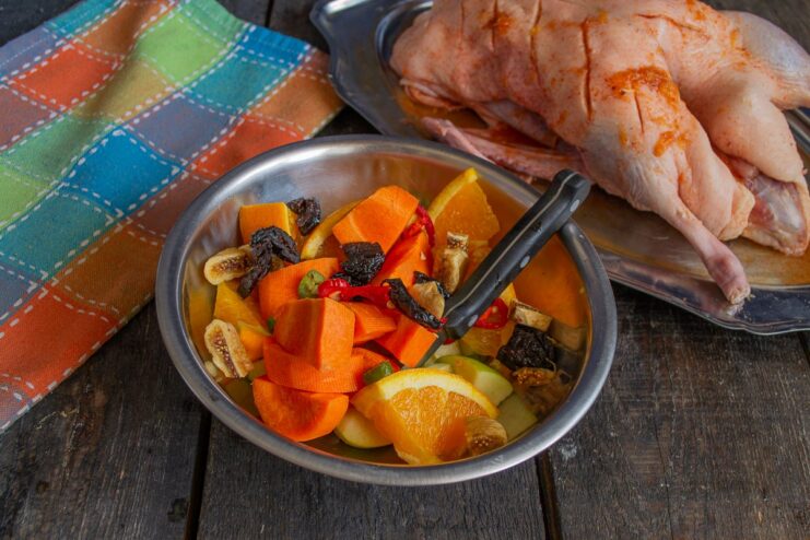 Adding Dried Fruits and Seasoning to the Stuffing Adding chopped prunes and figs to the fruit and vegetable stuffing mixture.