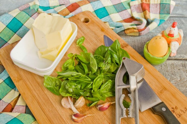 Aromatic filling for chicken cutlets made from butter, fresh basil, and garlic A small bowl with softened butter, chopped basil, and minced garlic for the filling.