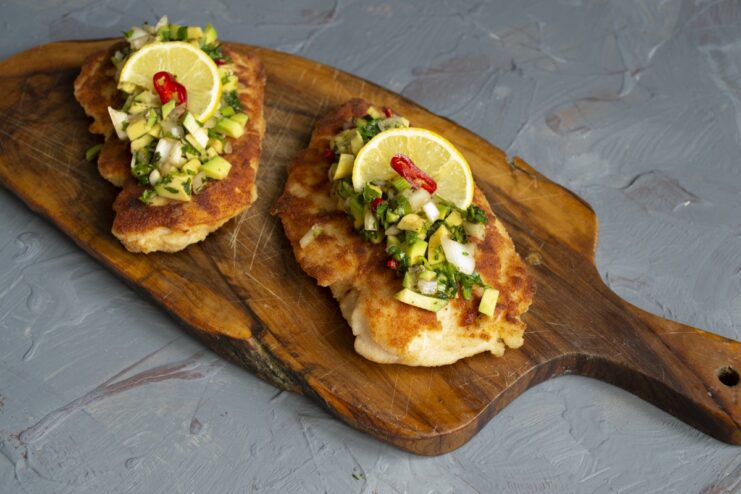 The finished dish: a perfect meal of chicken schnitzel and avocado salsa. The finished juicy breaded chicken schnitzel with avocado salsa, ready to be served.