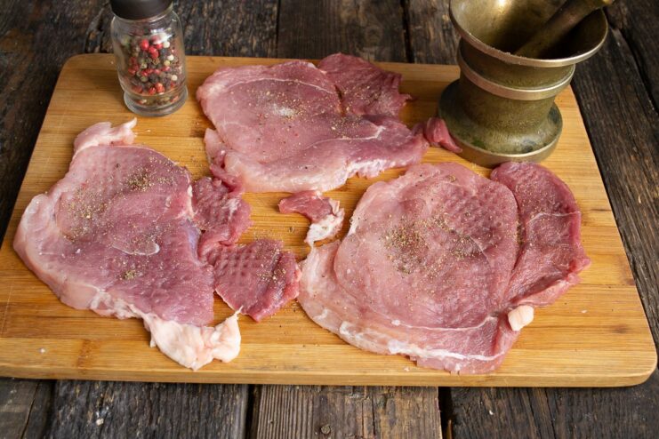 Seasoning the Pork Cutlets with Salt and Pepper Seasoning thin pork cutlets with freshly ground pepper and salt.