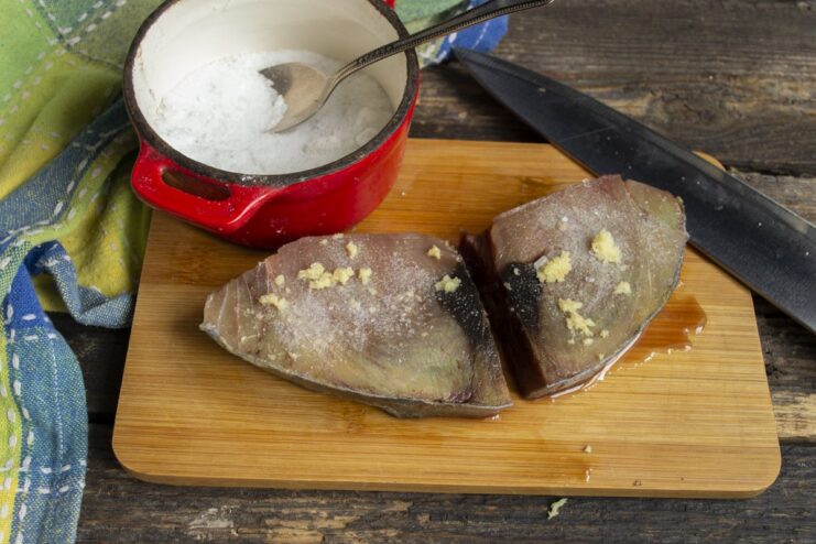 Seasoning the Tuna - Sprinkling the fish with salt to let the flavors absorb. A raw tuna steak being seasoned with salt before cooking.