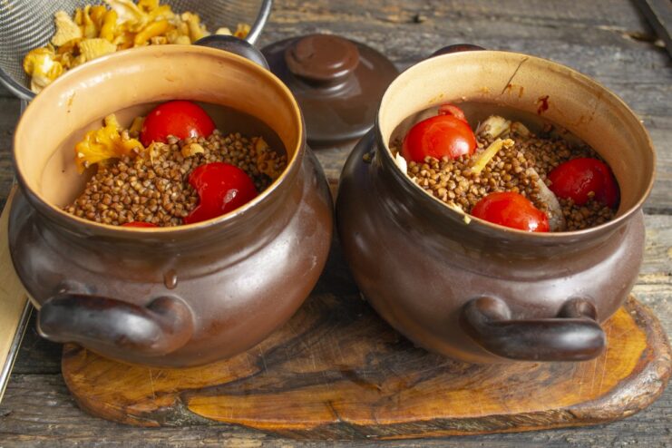 Topping with fresh tomatoes for moisture and flavor Halved tomatoes placed cut-side down on top of the buckwheat in the pot.