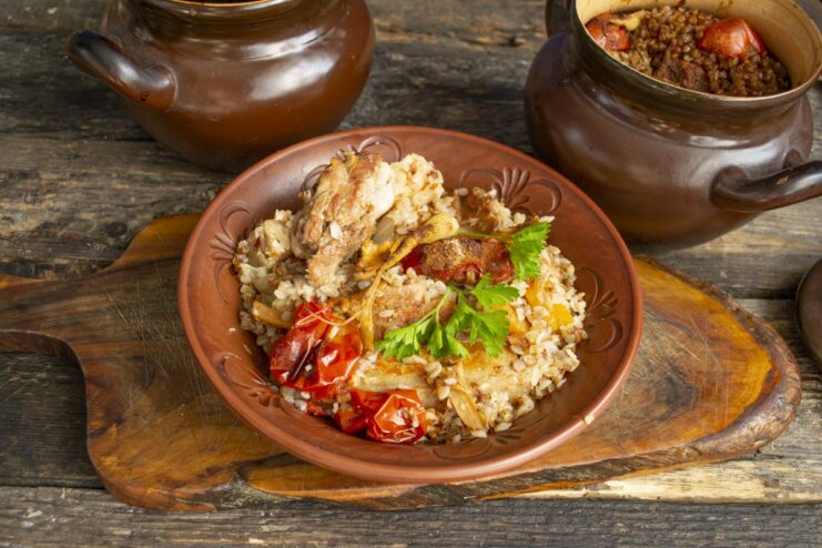 The finished dish, hot from the oven A finished dish of pork belly with buckwheat in a pot, ready to be served.