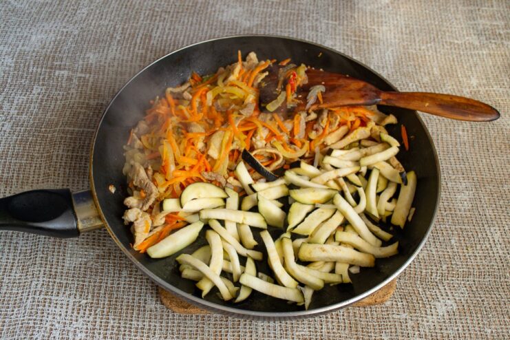 Step-by-Step: Sautéing Vegetables and Browning the Pork and Eggplant Sautéing pork, eggplant, onions, and carrots in a large pan.