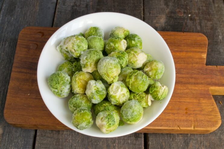 Quickly boiling Brussels sprouts to keep them crisp and vibrant. Frozen Brussels sprouts being added to a pot of boiling water.