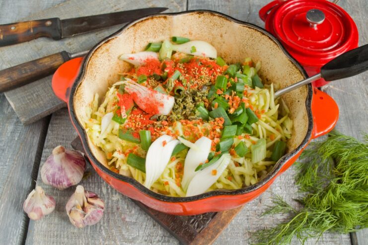 Layering Flavors with Spices and Fresh Green Onions A mix of spices and chopped green onions being added to the stew.