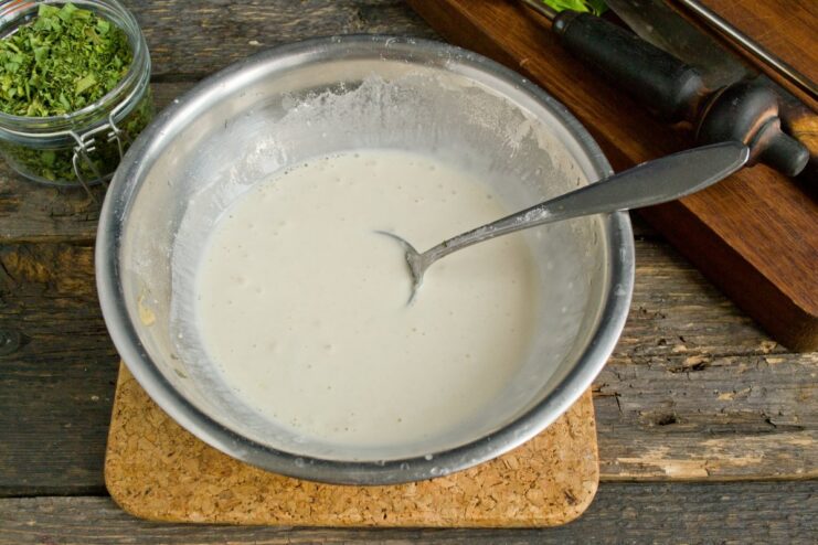 Creating the Creamy Sauce for the Pork Kidneys A bowl with flour, sour cream, and meat broth being whisked together to make a smooth sauce.