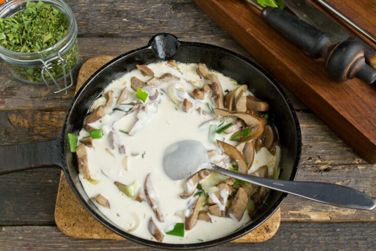 Simmering the Kidneys in the Creamy Gravy Pork kidneys simmering in a creamy gravy in a skillet, being stirred with a spatula.
