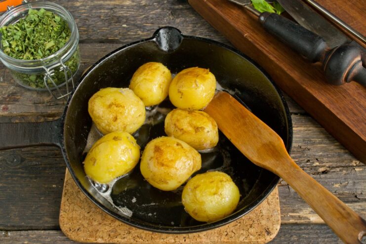 Pan-Frying Potatoes for a Crispy Side Dish Boiled new potatoes being pan-fried in a skillet until they have a crispy, golden-brown crust.