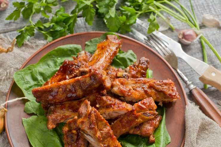 A platter of glossy, oven-baked pork ribs with honey sauce, ready to be served.