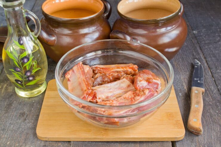 Marinating Pork Ribs: The Key to Tender and Flavorful Meat Raw pork ribs in a deep bowl, coated with a dark marinade of soy sauce and spices.