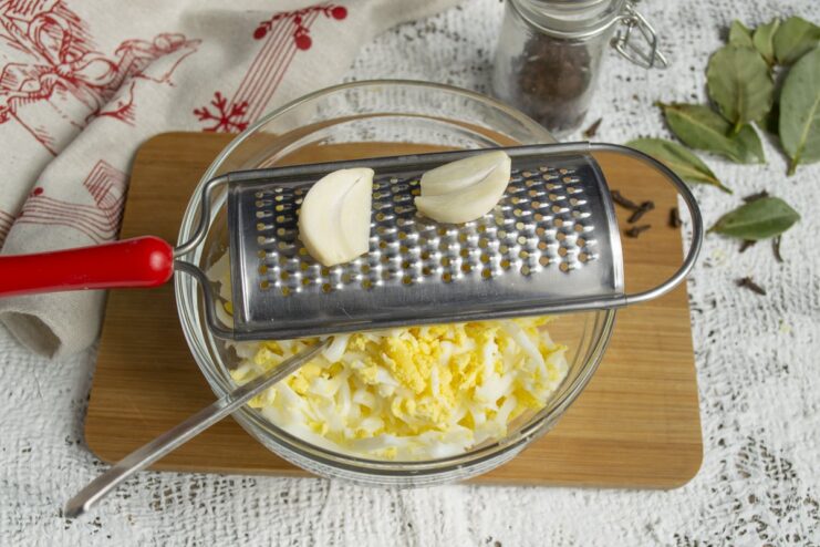 Mincing Garlic for a Savory Kick A close-up of minced garlic on a cutting board, ready to be added to the appetizer.