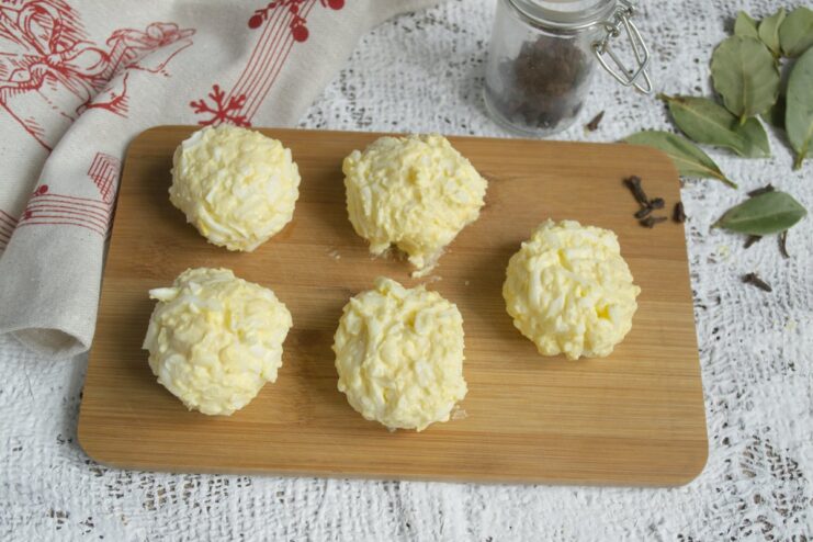 Forming the Cheese Mixture into Balls Hands rolling the cheese salad mixture into a small, neat ball.