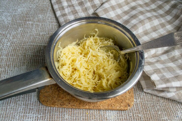 How to cook vermicelli so it doesn't stick together. Cooked vermicelli in a colander being mixed with a piece of butter.