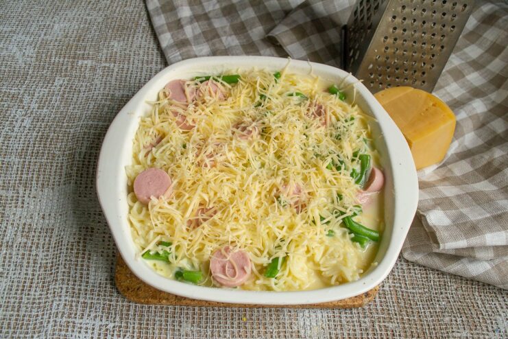Topping the casserole with cheese for a golden crust. Sprinkling grated cheese over the casserole before baking.