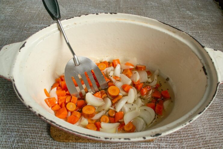 Sautéing Onions and Carrots with Aromatic Spices Chopped onions and carrots being added to the pan with toasted spices.