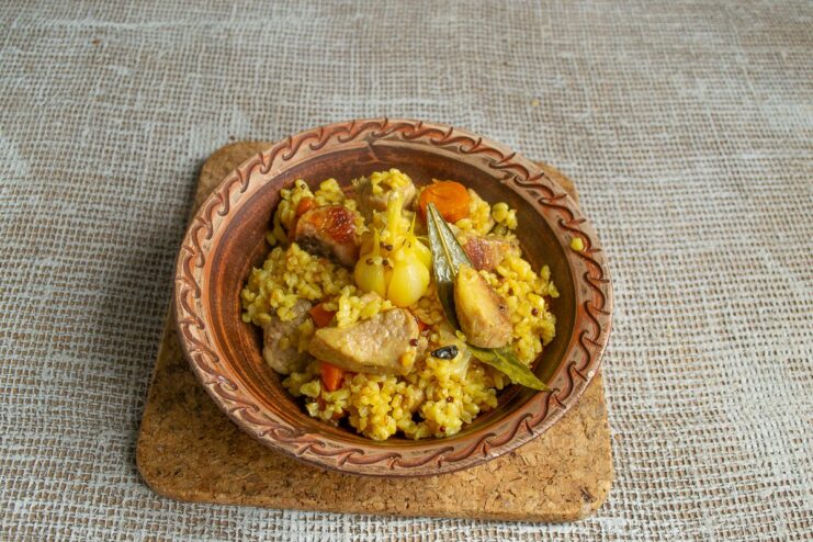 Serving the Deliciously Aromatic Bulgur Plov Hot A large platter of freshly cooked plov with bulgur and pork, ready to be served.
