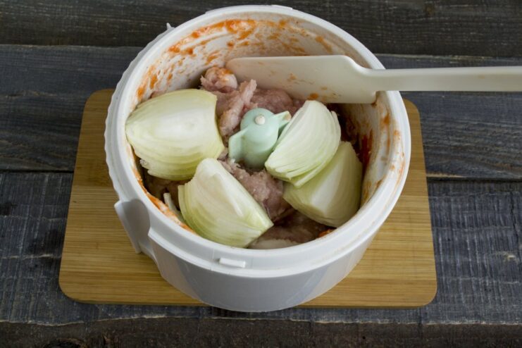 Adding chopped onion to the ground pork for extra flavor and moisture. Coarsely chopped white onion added on top of the ground pork in the blender.