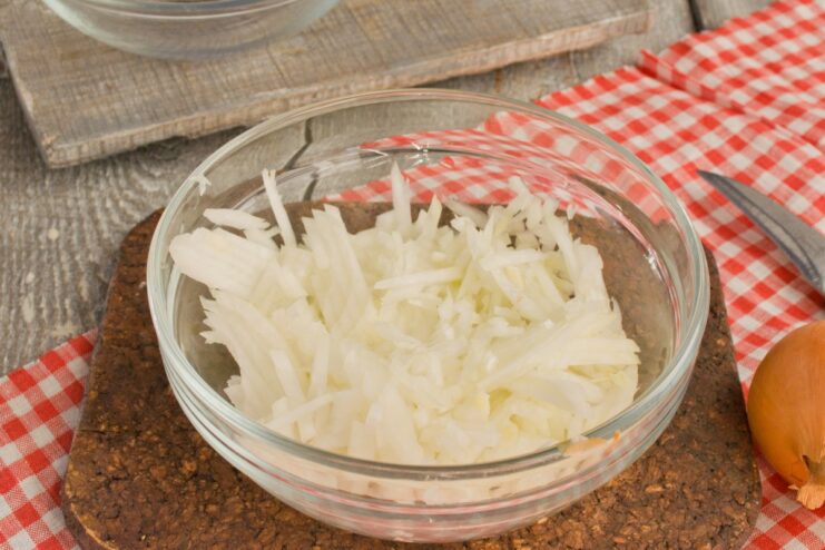 Finely Chopped Onion - Building the Flavor Base A pile of finely chopped yellow onion on a cutting board.