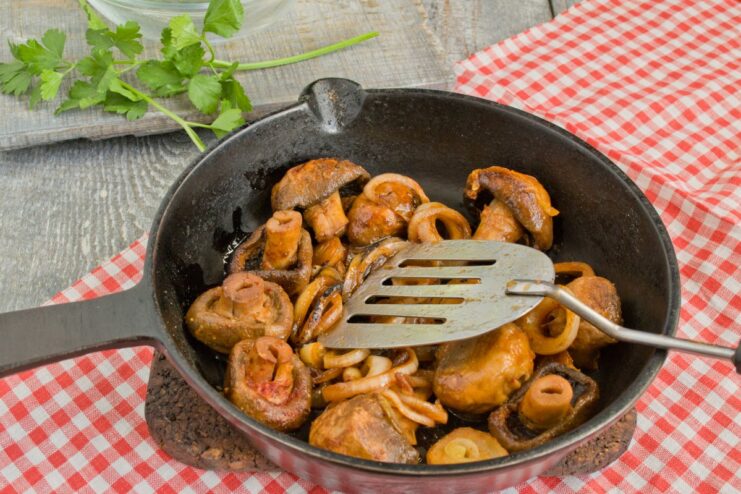 Searing Mushrooms to Golden Perfection Whole champignon mushrooms being sautéed in a pan until golden brown.