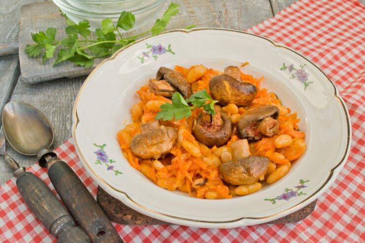 Serving the Delicious Stewed Beans and Mushrooms A serving of hot stewed beans with mushrooms in a bowl, ready to eat.