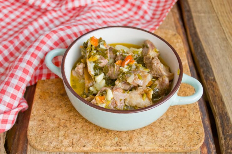 Serving the Hot and Tender Braised Pork A serving spoon scooping hot braised pork from a pot.