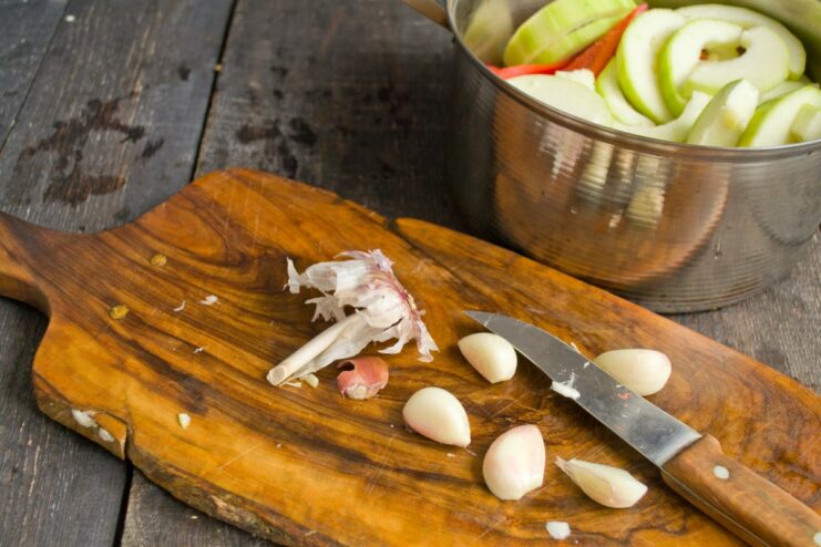 Adding Aromatic Garlic to the Vegetable Stew Peeled garlic cloves cut in half, ready to be added to the pot.