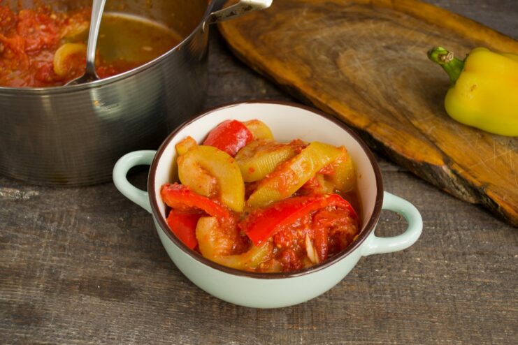 A Versatile Dish: Enjoy This Vegetable Stew Hot or Cold A serving of stewed zucchini, tomatoes, and peppers in a white bowl.