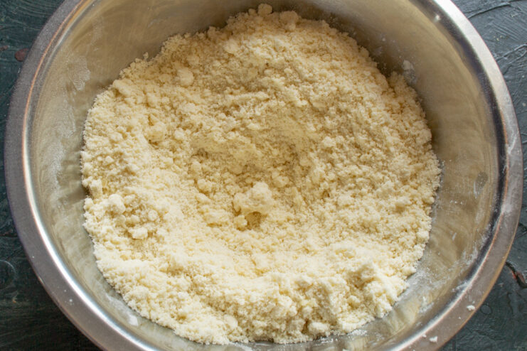 Creating a crumbly texture by hand Hands rubbing butter into a flour mixture to create fine crumbs for shortbread dough.