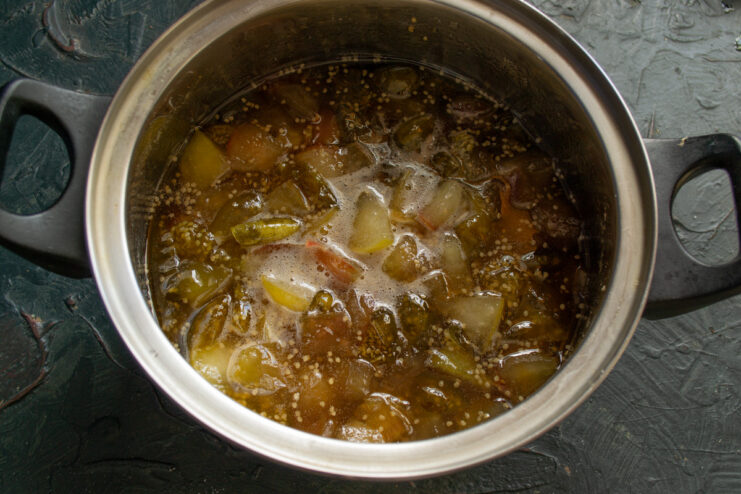 Checking for doneness: Look for translucent apples and no foam. The finished apple and physalis jam simmering in a pot, with translucent apple pieces.