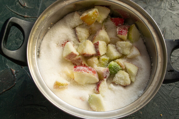 Step 4: Making the syrup base with water and sugar. A saucepan with water and granulated sugar being added to it.