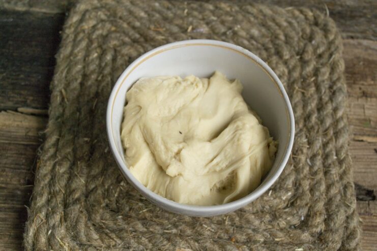 Step 1: Combining ingredients to make the perfect dough for vareniki. A glass bowl with flour and an egg cracked into it, ready for mixing the vareniki dough.