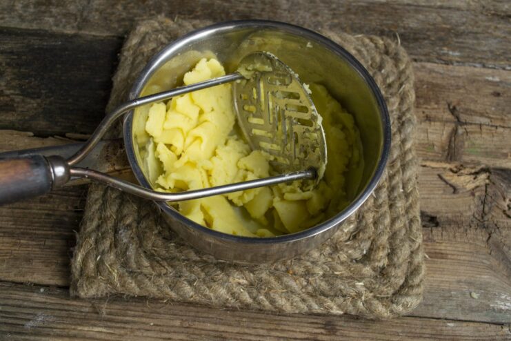 Preparing the creamy mashed potato filling for the vareniki. Mashed potatoes in a saucepan, being prepared for the filling.