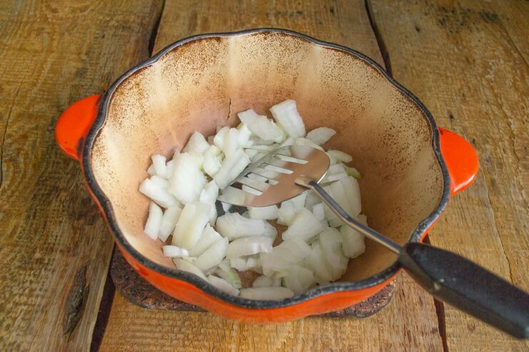 Step 2: Gently simmering chopped onions in a pot until soft. Chopped onions being sautéed in a heavy-bottomed pot.