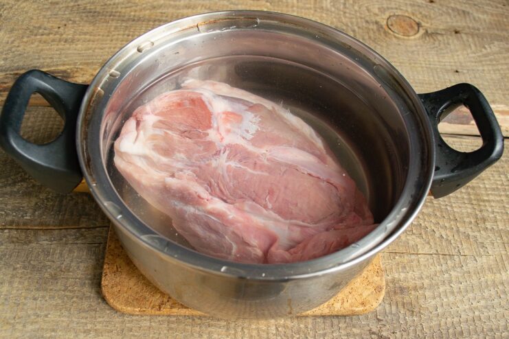 Step 1: Preparing the meat for boiling A piece of lean pork shoulder in a pot with water, ready for boiling.