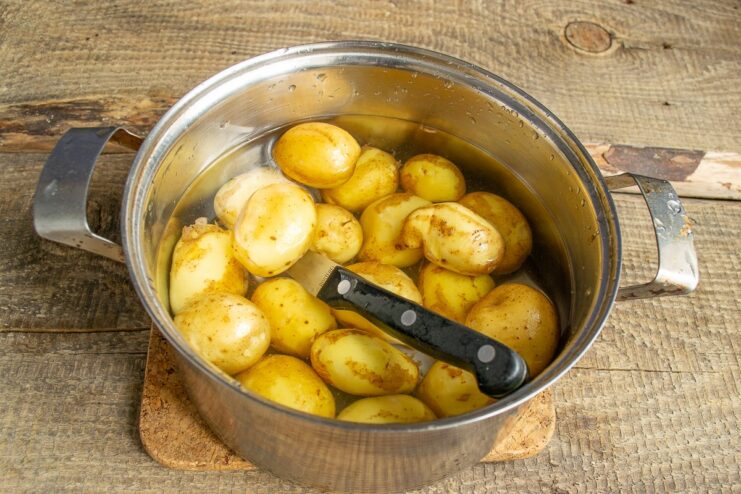 Cooking the new potatoes until perfectly tender New potatoes boiling in a separate pot of water.