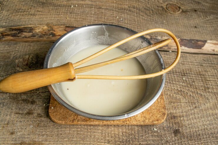Making the simple yet delicious broth-based sauce Whisking flour into the meat broth in a bowl to create the sauce base.