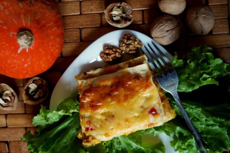 Freshly baked pumpkin lasagna, golden and bubbly A baking dish with freshly baked vegetarian pumpkin lasagna, showing a golden-brown cheesy crust.