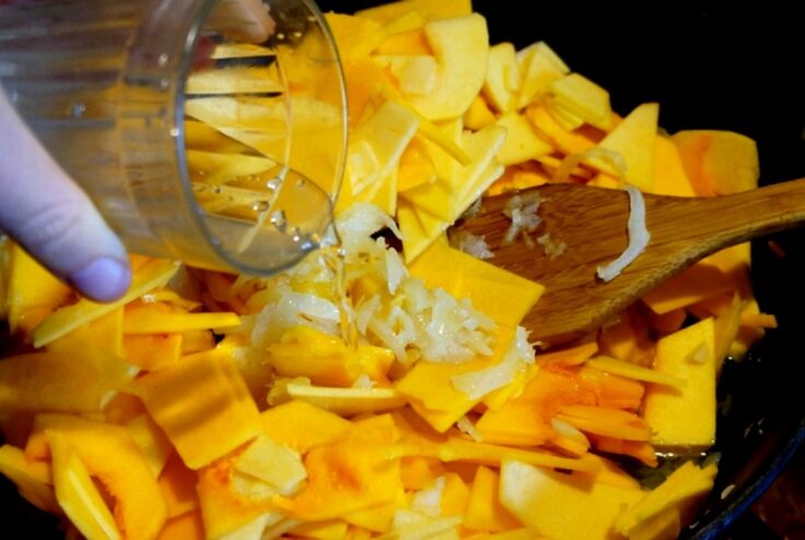 Cooking the pumpkin and onion filling until tender Pumpkin and onion simmering in a frying pan to create the savory lasagna filling.