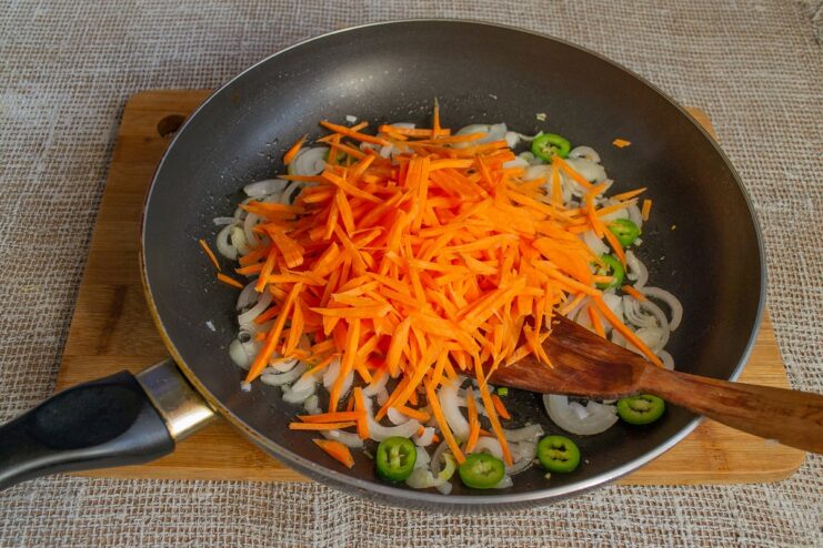 Sautéing onions, carrots, and other vegetables for the filling A mix of chopped vegetables being sautéed in a frying pan.