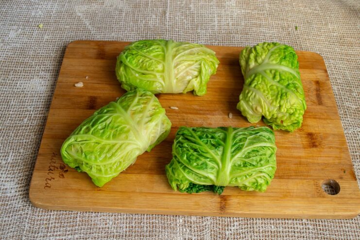 Folding the cabbage leaf into a neat roll or parcel A savoy cabbage leaf being neatly folded around the filling to form a roll.