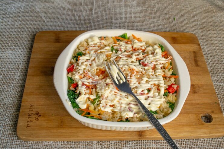 Topping the gratin with vegan mayonnaise for a creamy, golden-brown crust. Spreading a layer of vegan mayonnaise on top of the gratin before baking.