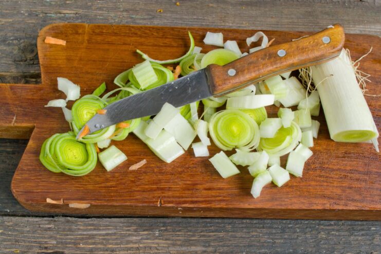 Dicing celery stalks for the vegetable marinade Celery stalks being finely chopped into small cubes on a cutting board.