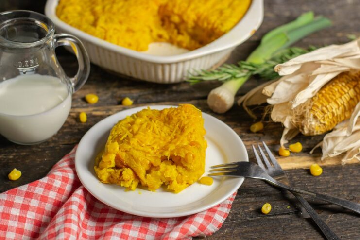 A slice of vibrant cheddar corn pie on a plate, ready to be served.