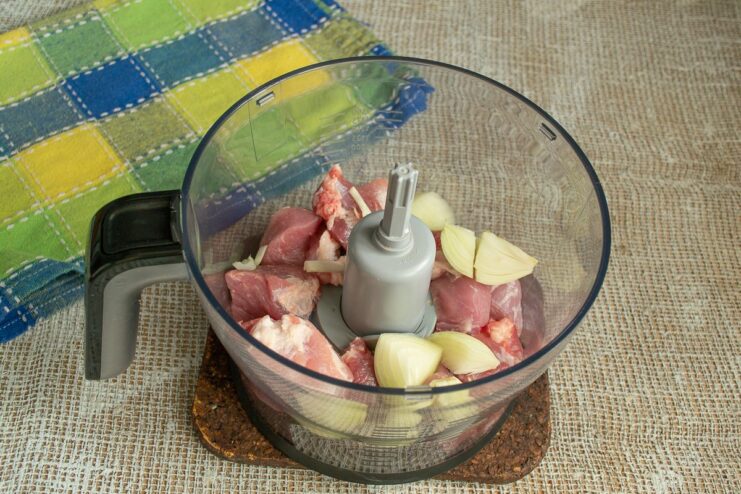 Preparing the Pork Mince for Scotch Eggs Cubes of pork and onion in a blender bowl with a splash of water, ready to be mixed.