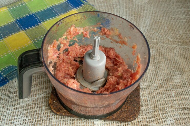 Seasoning and Grinding the Meat Mixture Seasoning the pork and onion mixture in a blender before grinding it into a paste.