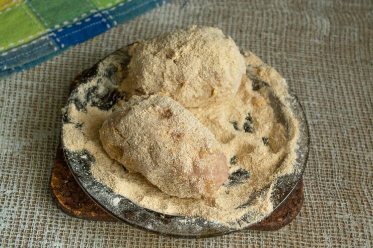 Final Breading: Egg Wash and Breadcrumbs for a Crispy Crust Coating the flour-dusted Scotch egg in breadcrumbs after an egg wash.