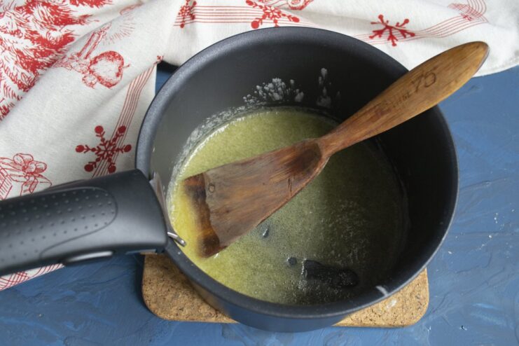 Creating a roux with butter and flour as the base for the creamy sauce. Melting butter and flour in a saucepan to make a golden roux.