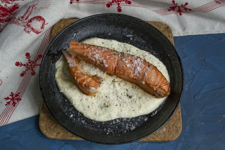 Topping the trout with coconut and pepper before baking adds texture and flavor. Trout in a skillet topped with shredded coconut, ready for the oven.